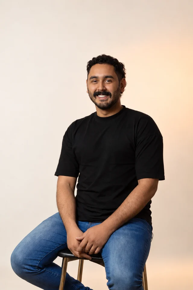 Gui Sanuza sorrindo em um retrato de estúdio com fundo claro e luz suave